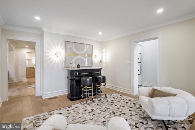 sitting room with light hardwood / wood-style floors and crown molding