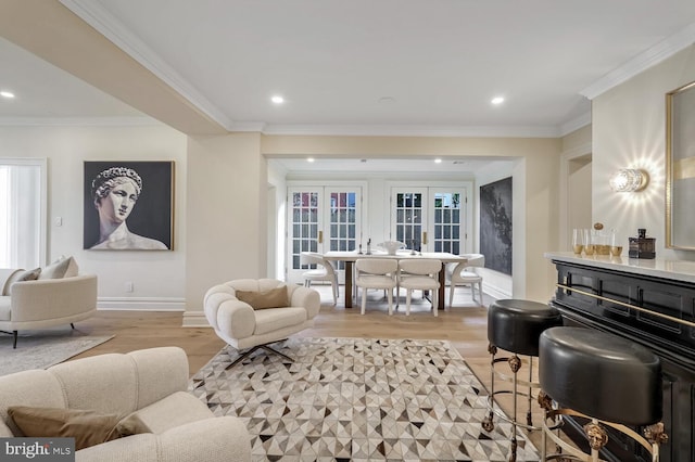 living room featuring french doors, light wood-type flooring, and crown molding