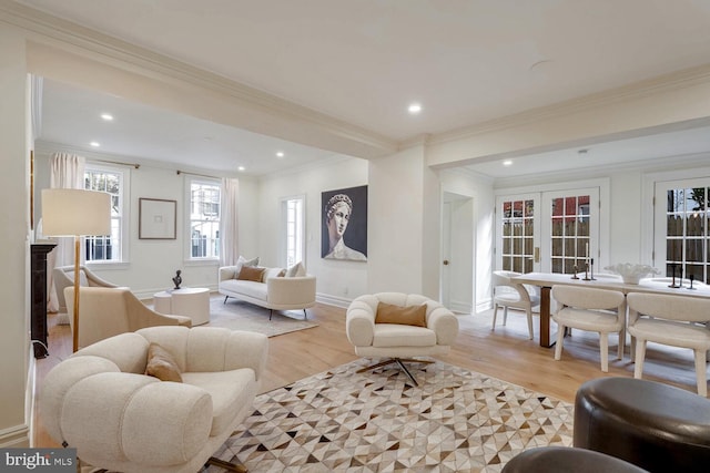 living room with french doors, light hardwood / wood-style floors, and crown molding