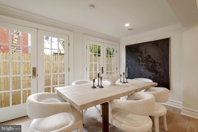 interior space with french doors, hardwood / wood-style floors, and crown molding