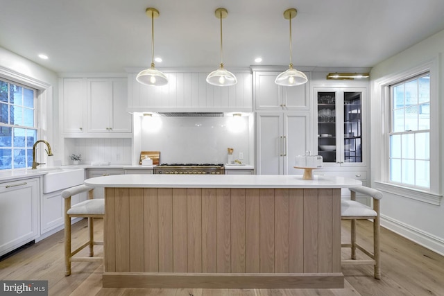 kitchen with sink, decorative light fixtures, a kitchen bar, and a center island