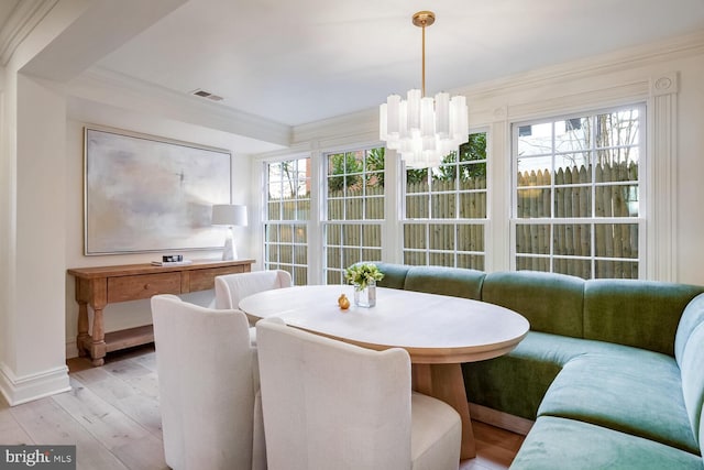 dining room featuring breakfast area, plenty of natural light, crown molding, and light hardwood / wood-style flooring