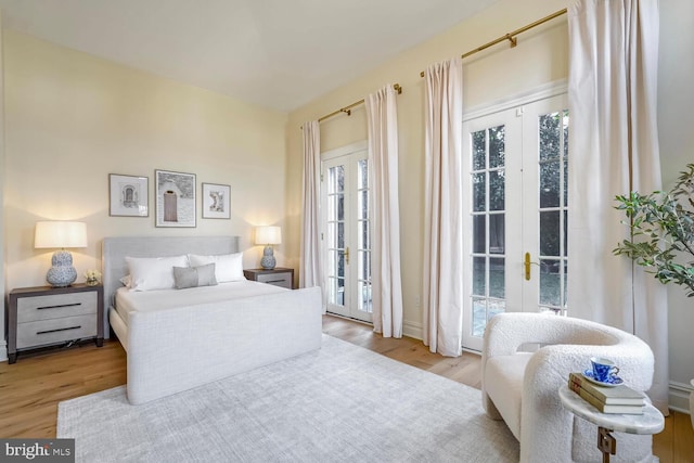 bedroom with french doors, access to outside, and light wood-type flooring