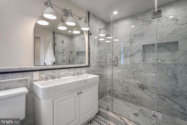 bathroom featuring tile walls, toilet, walk in shower, and vanity