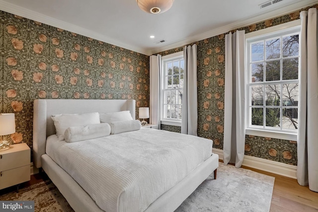 bedroom with ornamental molding and hardwood / wood-style floors