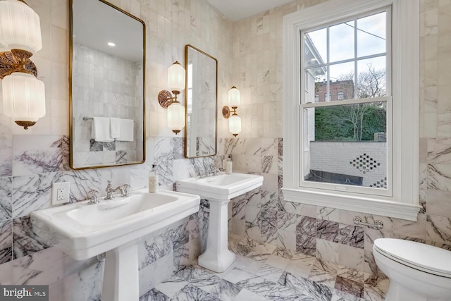 bathroom with tile walls and double sink