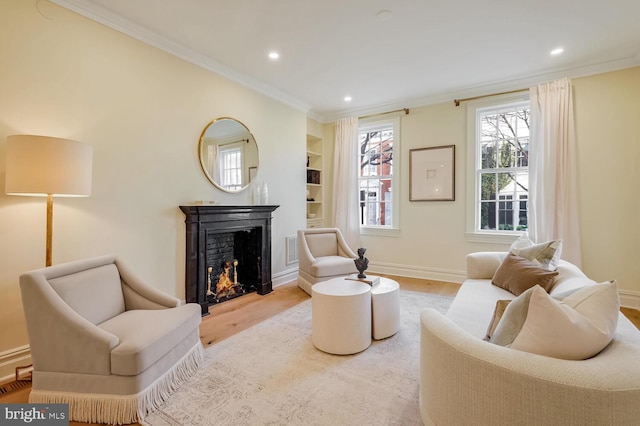 living room featuring light wood-type flooring, built in features, and crown molding