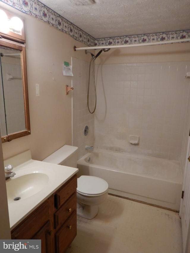 full bathroom with tiled shower / bath combo, toilet, a textured ceiling, and vanity