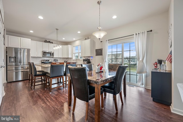 dining area featuring sink and dark wood-type flooring