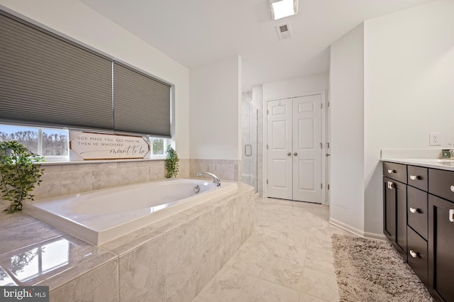 bathroom featuring vanity, plenty of natural light, and independent shower and bath