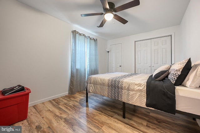 bedroom with hardwood / wood-style flooring, ceiling fan, and a closet