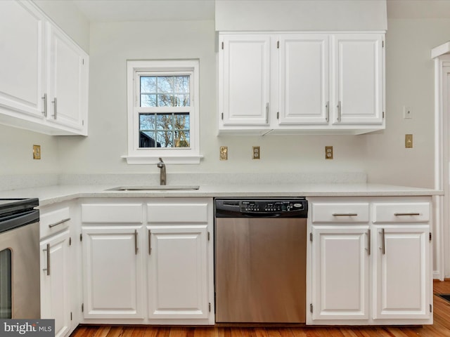 kitchen featuring range, white cabinetry, stainless steel dishwasher, and sink