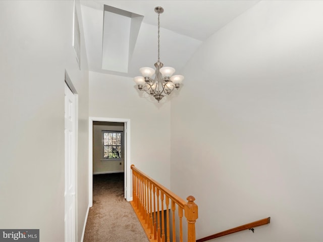 hall with light colored carpet, an inviting chandelier, and lofted ceiling