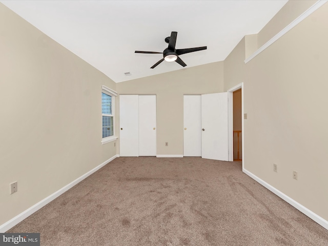 unfurnished bedroom featuring carpet flooring, vaulted ceiling, and ceiling fan