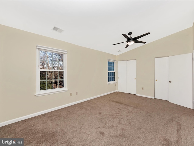 unfurnished bedroom with multiple closets, carpet floors, ceiling fan, and lofted ceiling