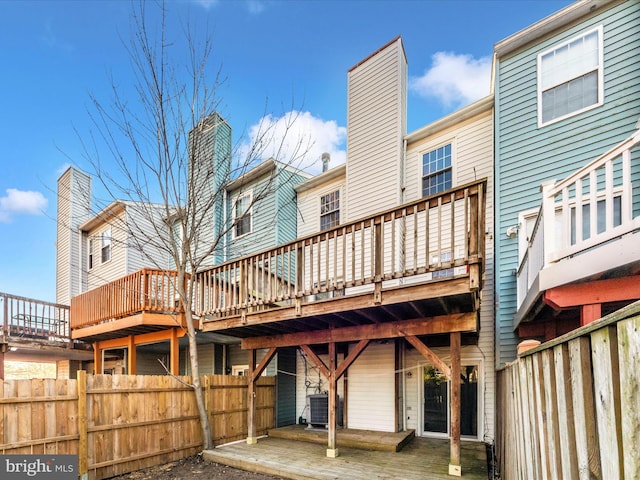 back of house featuring central AC unit and a wooden deck