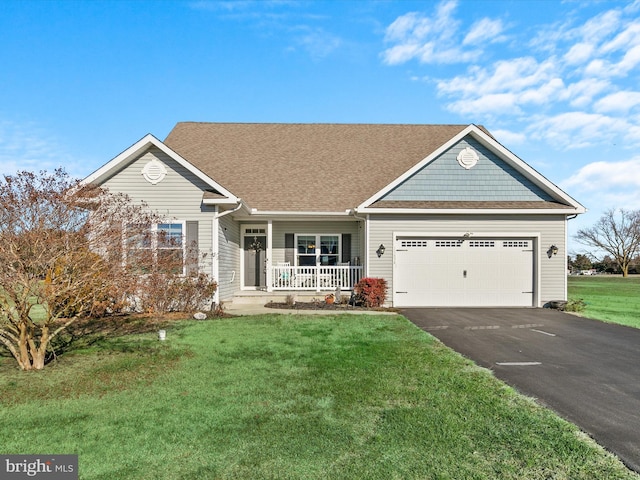 view of front of home with covered porch, a front yard, and a garage