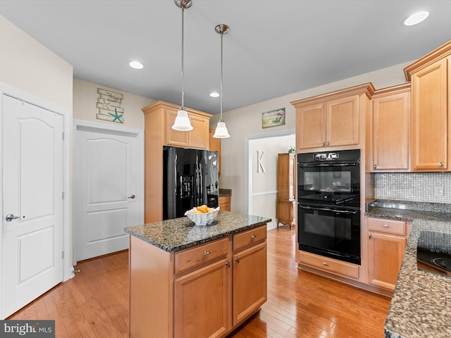 kitchen featuring tasteful backsplash, dark stone counters, black appliances, light hardwood / wood-style floors, and hanging light fixtures