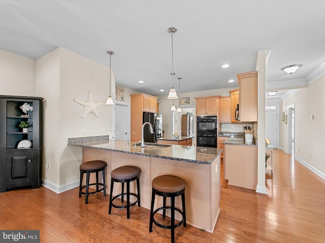 kitchen featuring sink, hanging light fixtures, stainless steel fridge with ice dispenser, double oven, and kitchen peninsula