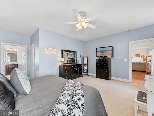 bedroom featuring light carpet, ensuite bath, and ceiling fan