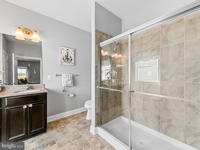 bathroom featuring vanity, toilet, and a shower with shower door