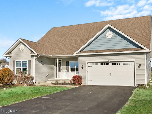 view of front of home with a front yard, a porch, and a garage