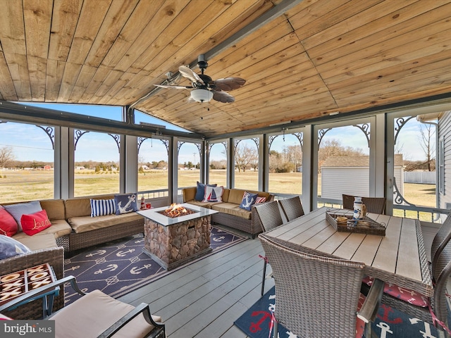 sunroom / solarium featuring vaulted ceiling, ceiling fan, and wood ceiling