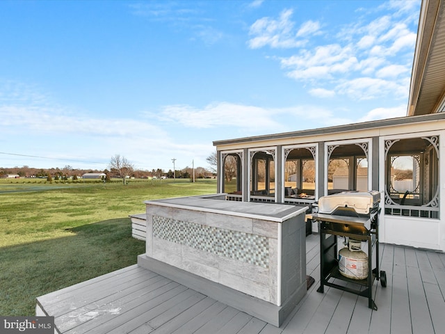 wooden deck with area for grilling, a sunroom, and a yard