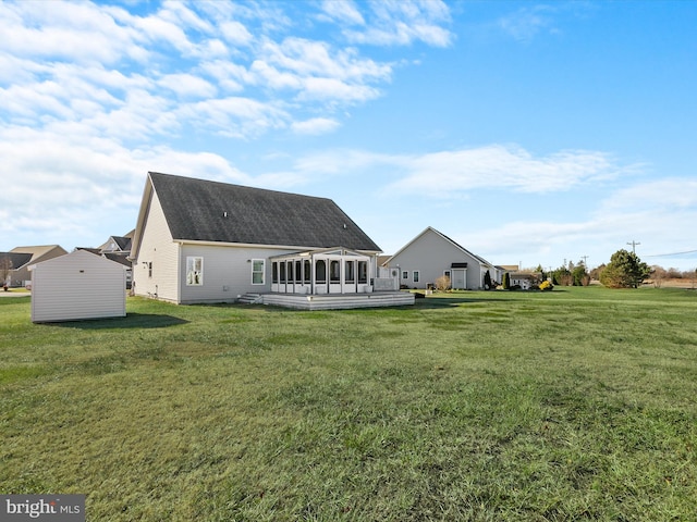 rear view of property featuring a sunroom and a yard