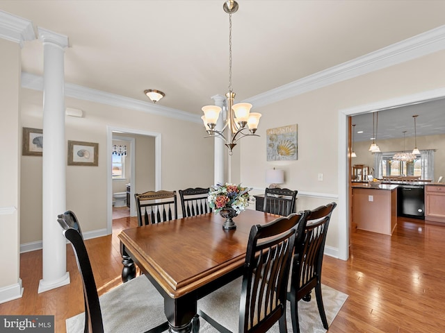 dining space featuring a chandelier, light hardwood / wood-style flooring, ornamental molding, and ornate columns