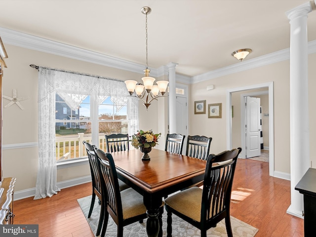 dining room with a chandelier, light wood-type flooring, ornate columns, and ornamental molding