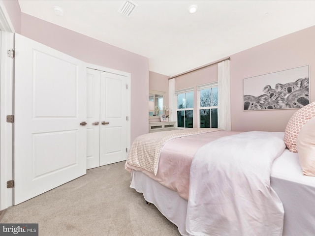 bedroom featuring light colored carpet and a closet