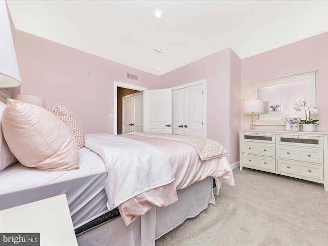 bedroom featuring light colored carpet and a closet