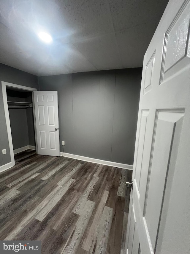 unfurnished bedroom featuring a closet and dark hardwood / wood-style floors