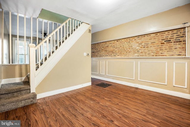 interior space featuring hardwood / wood-style floors and brick wall