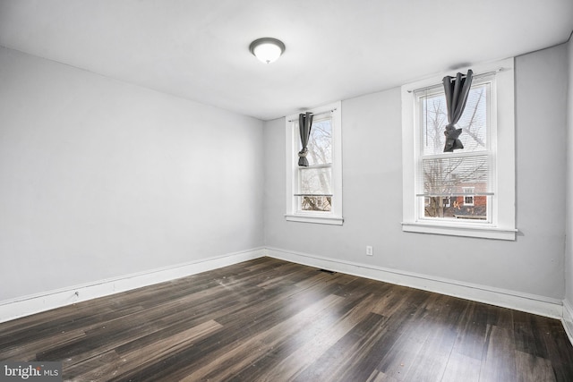 spare room featuring dark wood-type flooring