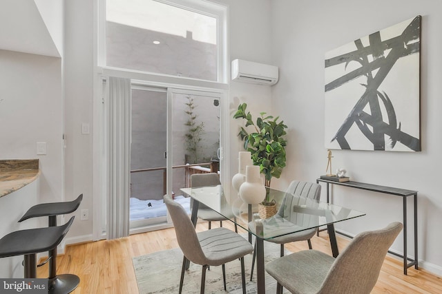 dining area featuring light wood-type flooring and a wall mounted AC