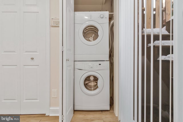 washroom with light wood-type flooring and stacked washer / dryer