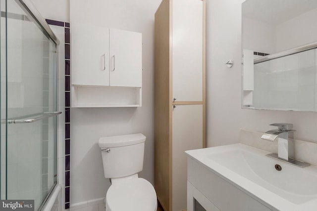 full bathroom with enclosed tub / shower combo, vanity, and toilet