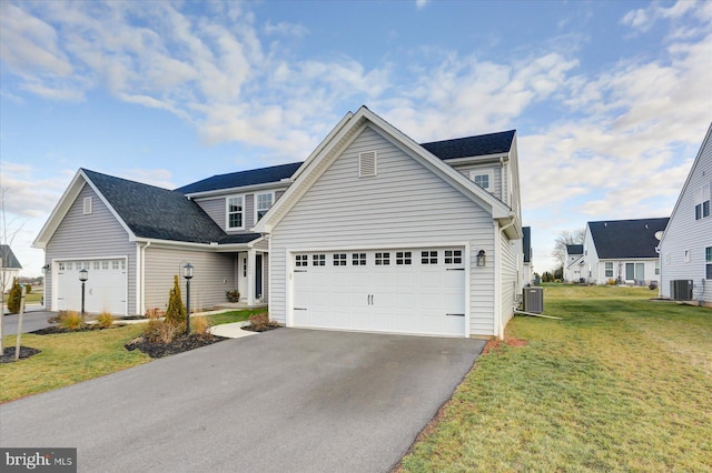 front of property featuring a garage, a front lawn, and cooling unit