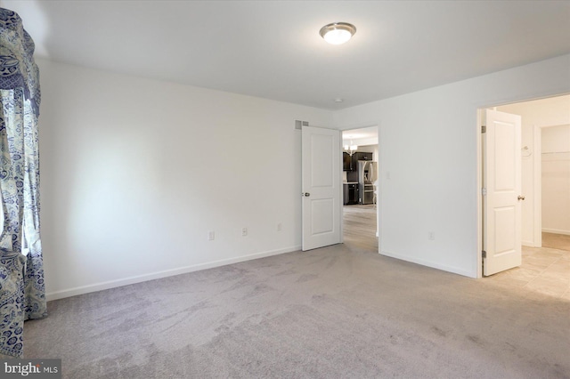 unfurnished bedroom with a spacious closet and light carpet