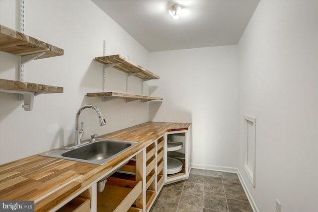 bar with butcher block countertops and sink