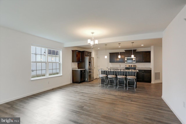 dining space with a chandelier, dark wood-type flooring, and sink