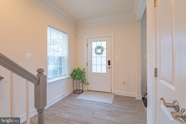 foyer entrance with crown molding and light wood-type flooring