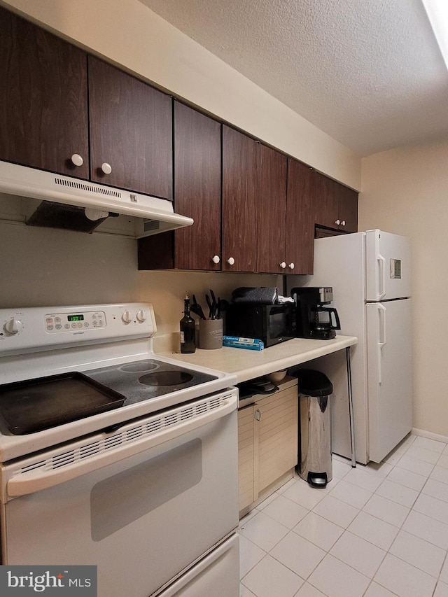 kitchen featuring a textured ceiling, light tile patterned floors, dark brown cabinets, and white appliances