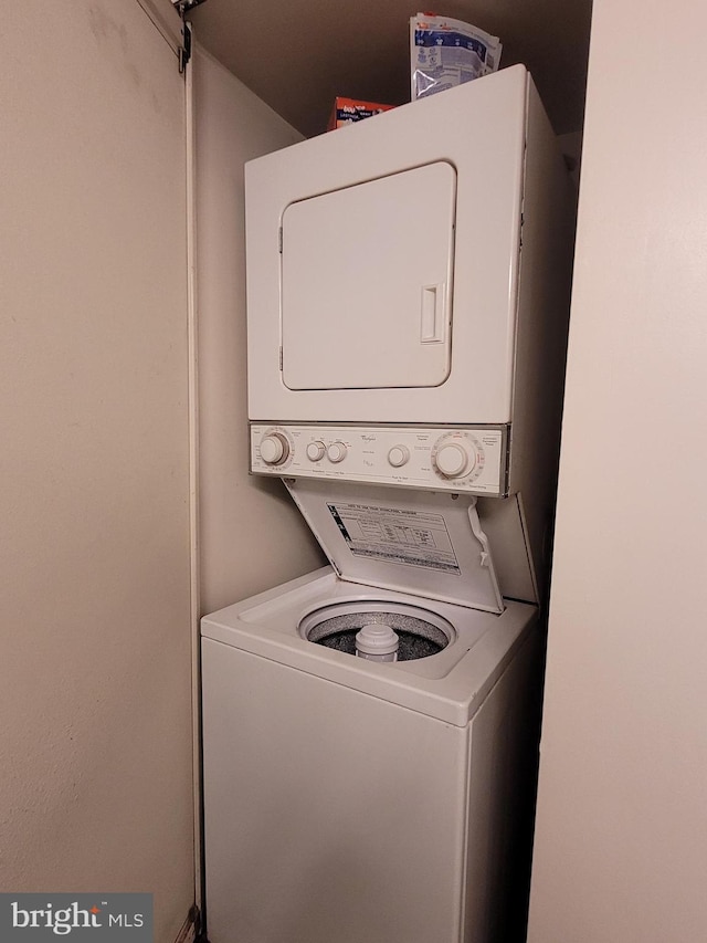 clothes washing area with stacked washer / dryer