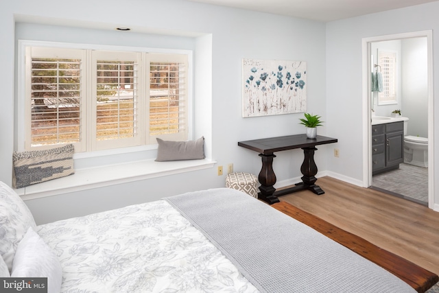 bedroom with wood-type flooring and ensuite bath