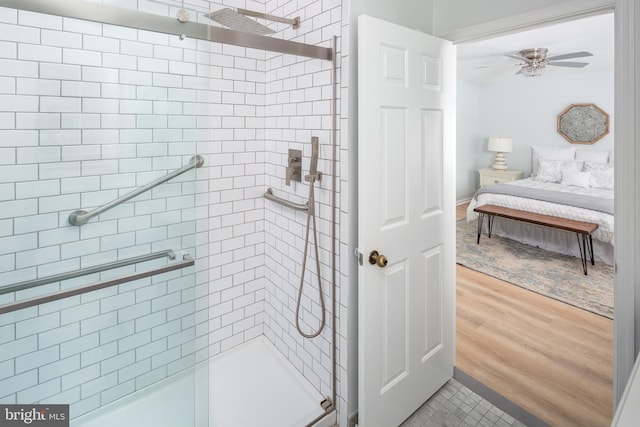 bathroom with ceiling fan, hardwood / wood-style floors, and an enclosed shower