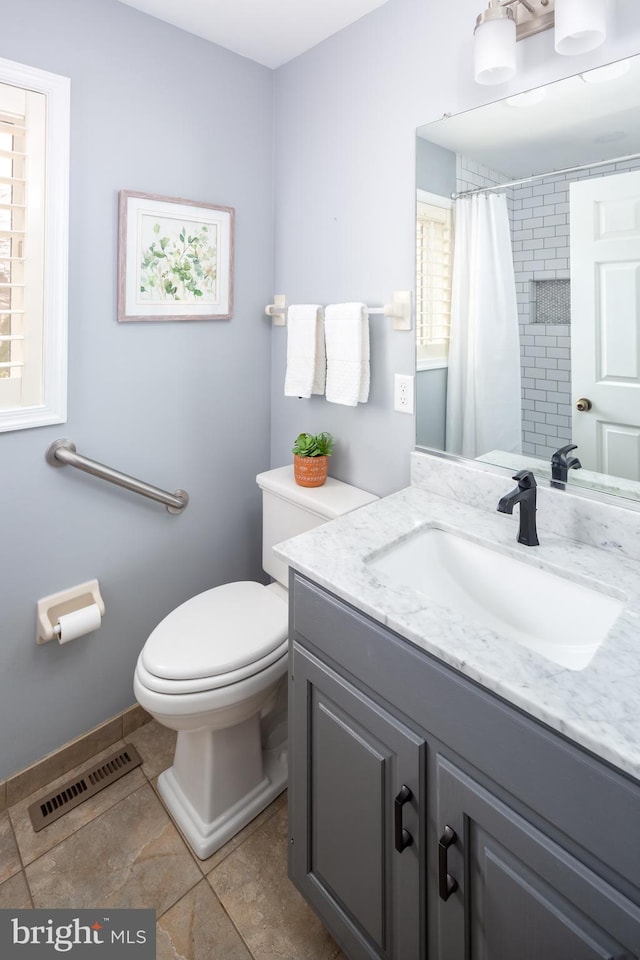 bathroom featuring toilet, vanity, a shower with curtain, and tile patterned flooring