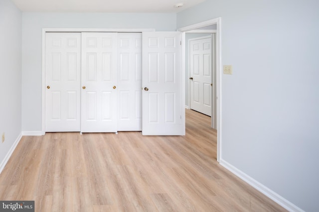 unfurnished bedroom featuring a closet and light hardwood / wood-style floors